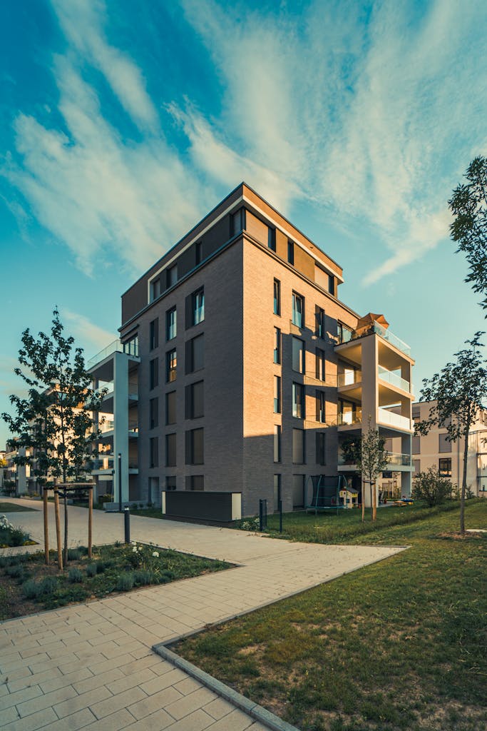 A modern apartment building with a green lawn