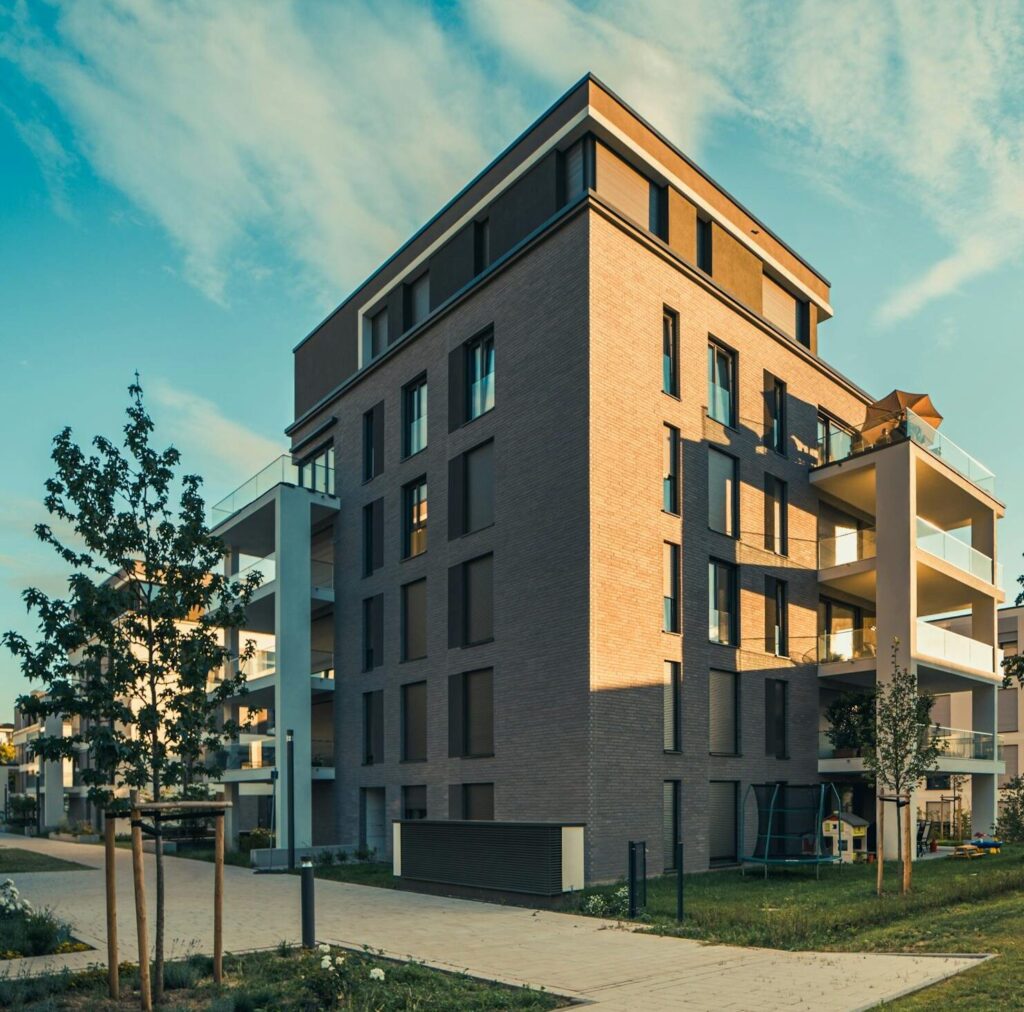 A modern apartment building with a green lawn